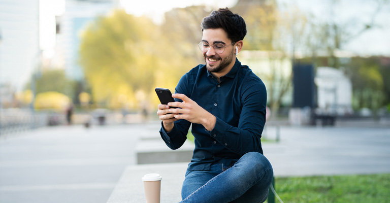 AY YILDIZ Kunde mit Smartphone und AirPods freut sich über doppeltes Datenvolumen