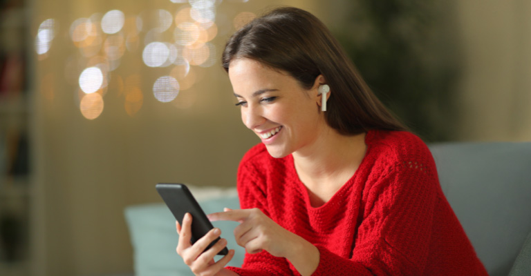AY YILDIZ Kundin nutzt Smartphone mit AirPods und Treuebonus ab der 1. Verlängerung